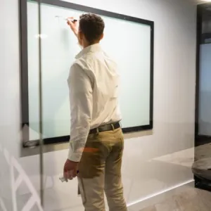 A presenter sketching on a glass whiteboard